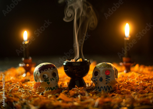 Altar de día de muertos noviembre méxico incienso copal flor de cempasúchil contraluz calaveras de azúcar tradiciones otoño velas photo