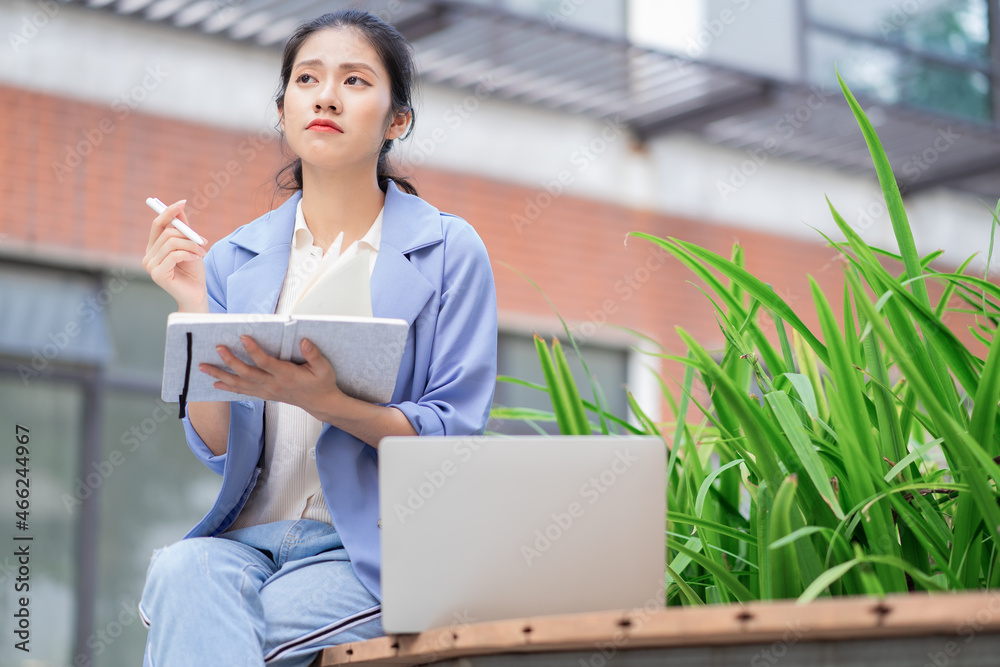 Young Asian woman working outside Young Asian woman working outside