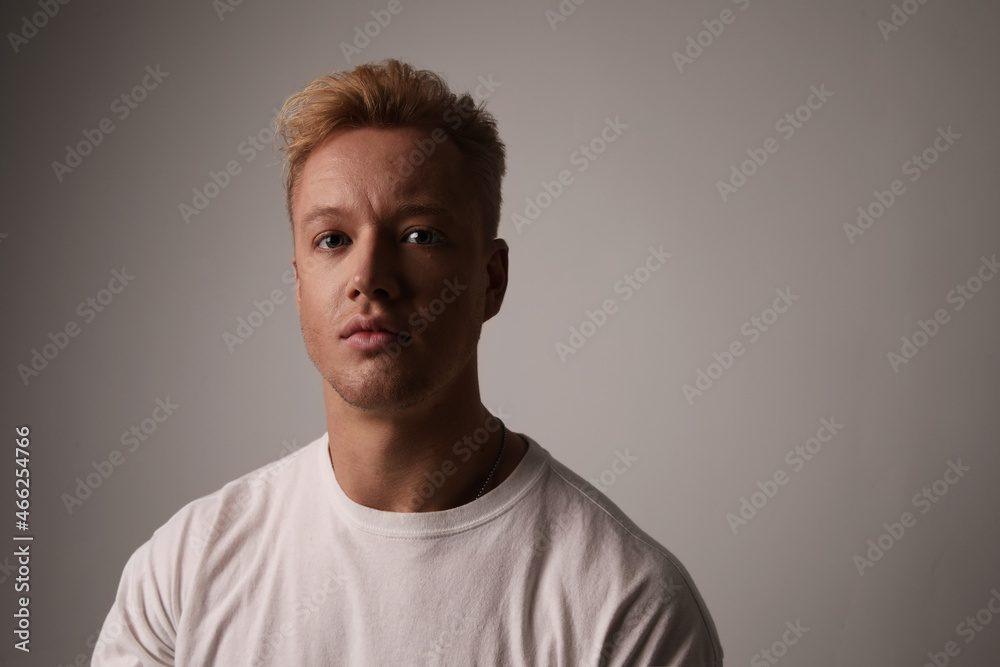 Obraz premium Portrait of a handsome young man posing against white wall. Space for text.