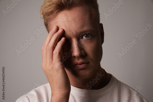Portrait of a stressed man sitting against white background. Problem and stress. © face_reader_img