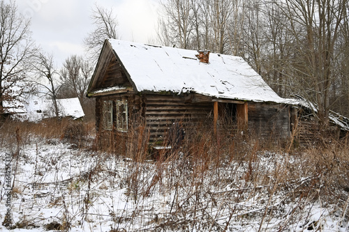 Photography An old dilapidated wooden farmhouse in winter landscape