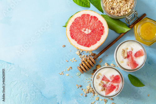 Vegan healthy breakfast. Granola with greek yogurt, honey and grapefruit in a glass. Top view flat lay background. Copy space.