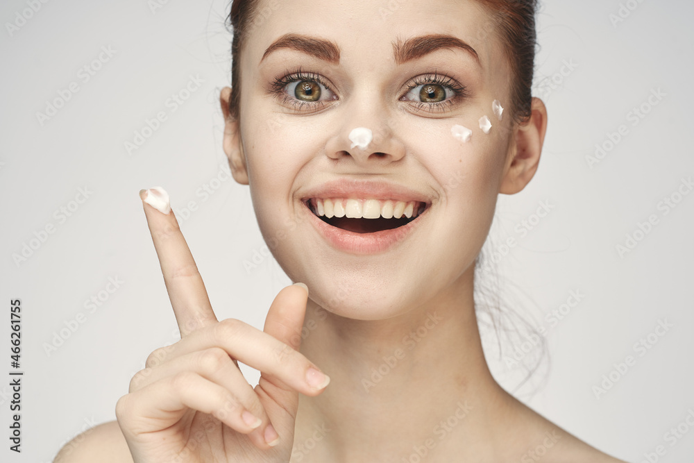 woman with face cream naked shoulders cosmetics face care