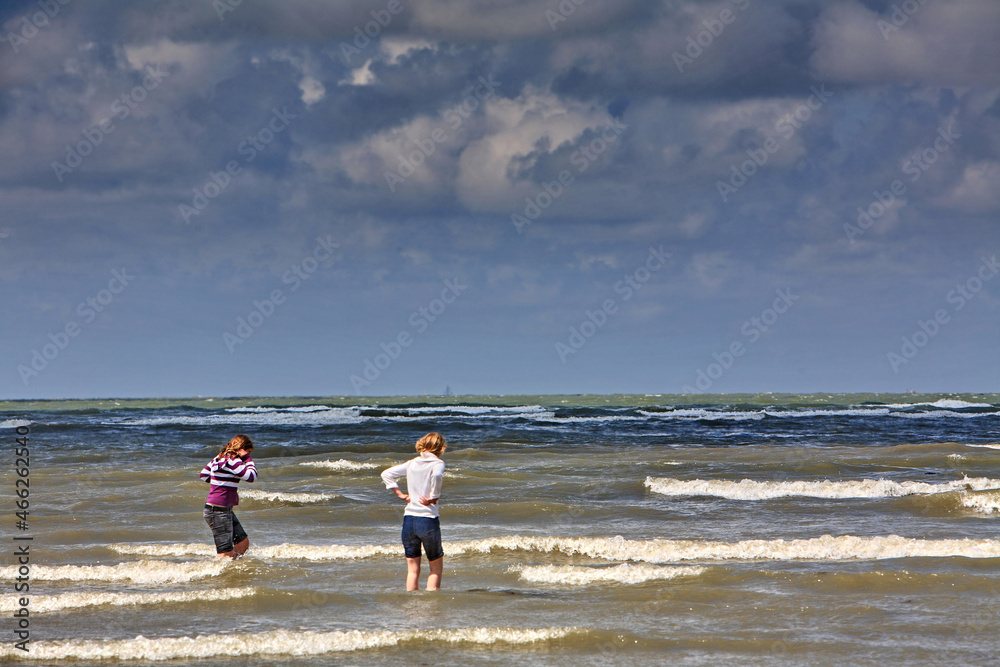 deux jeunes filles marchant dans les vagues deux jeunes filles marchant dans les vagues