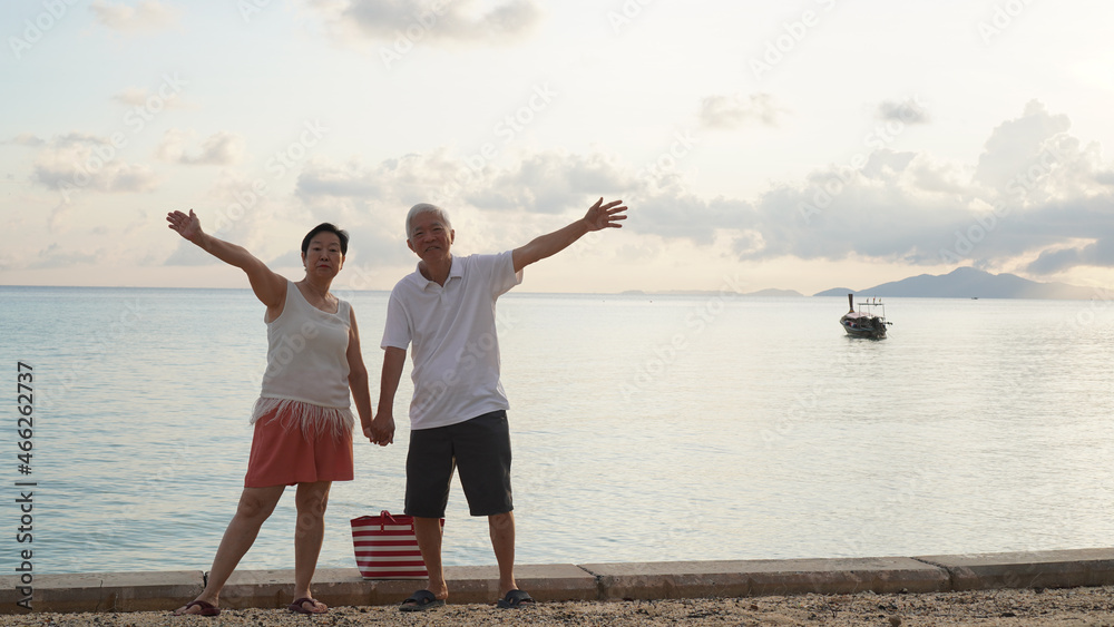 Fototapeta premium Asian elder senior couple retirement fun beach ocean trip healthy relationship and financial