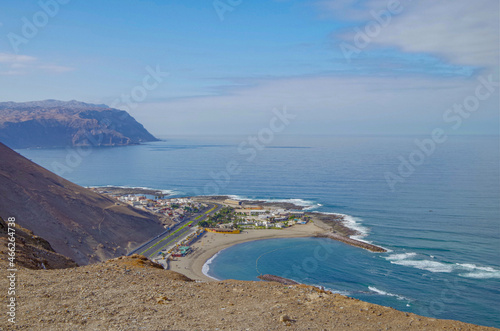 Panoramic landscape scenic view from hilltop viewing point outlook Morro de Arica over downtown and port skyline over surrounding nature with ocean and mountain dusty sand dune desert in Chile photo