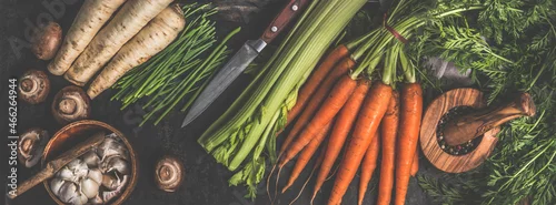 Obraz  z motywem Various vegetables and kitchen utensils on dark rustic kitchen table: Carrots, garlic, mushrooms, celery and parsnip. Healthy lifestyle with vegetarian food. Top view. Banner.