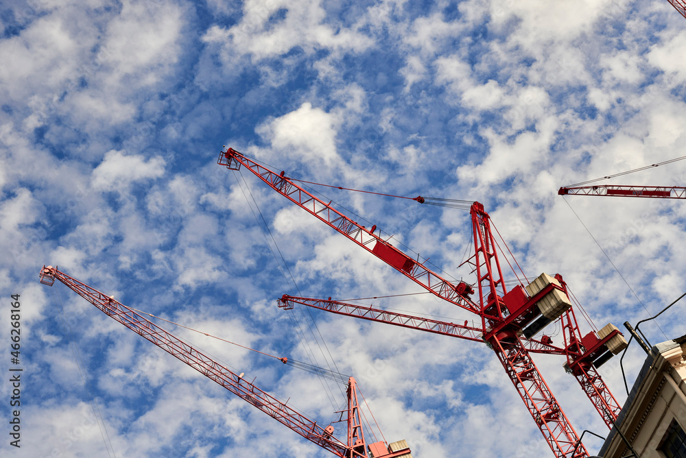 Construction red cranes over cloudy sky Construction red cranes over cloudy sky