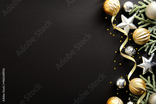 Black Christmas background with golden and silver decorations, fir tree branches, ribbon. Christmas holiday celebration, winter, New Year concept. Christmas banner mockup, greeting card template