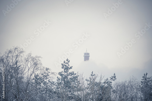 Top of power plant chimney in winter, Gariūnai, Vilnius, Lithuania. Cold winter day, environmental pollution concept. Selective focus on built structure, blurred background. photo