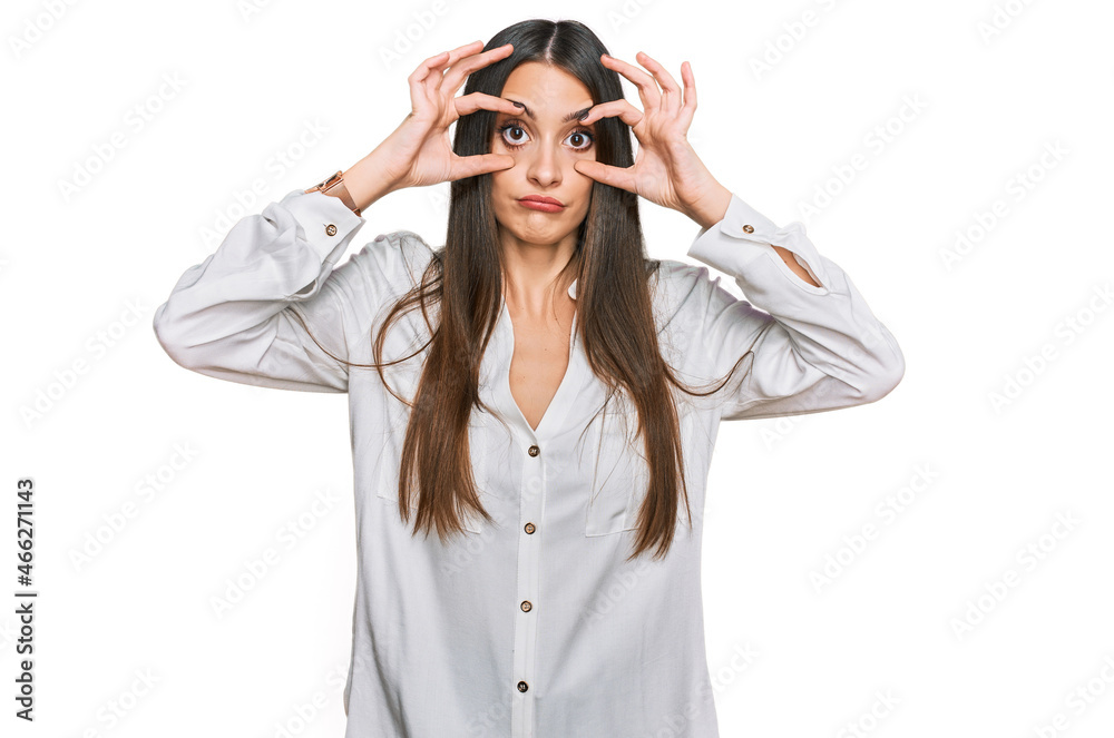 Young beautiful woman wearing casual white shirt trying to open eyes with fingers, sleepy and tired for morning fatigue Young beautiful woman wearing casual white shirt trying to open eyes with fingers, sleepy and tired for morning fatigue