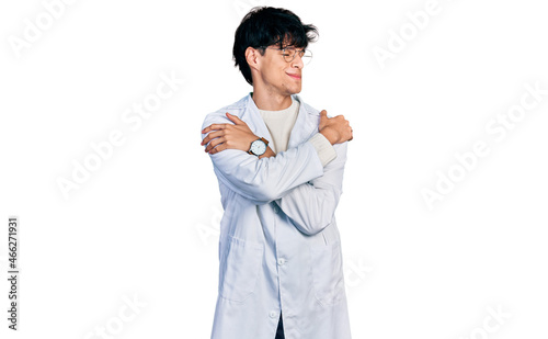 Handsome hipster young man wearing doctor uniform hugging oneself happy and positive, smiling confident. self love and self care
