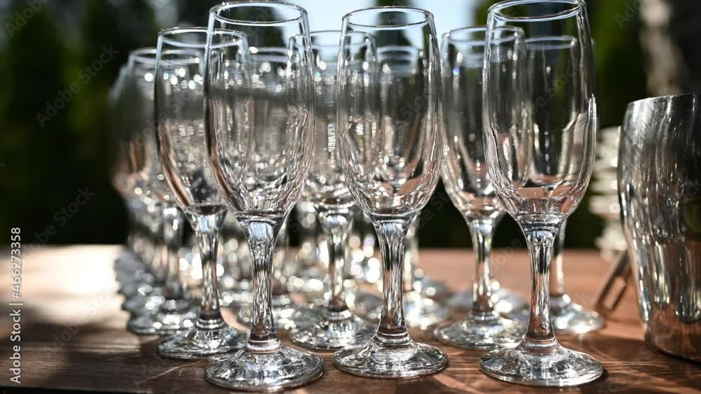 Row of crystal wine and champagne glasses standing on banquet table Row of crystal wine and champagne glasses standing on banquet table