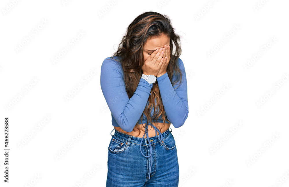 Young hispanic girl wearing casual clothes with sad expression covering face with hands while crying. depression concept. Young hispanic girl wearing casual clothes with sad expression covering face with hands while crying. depression concept.