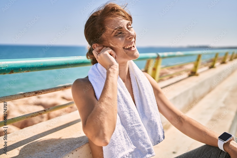 Young caucasian woman wearing sportswear resting at seaside