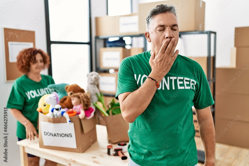 © Krakenimages.com - Middle age man wearing volunteer t shirt at donations stand bored yawning tired covering mouth with hand. restless and sleepiness. © Krakenimages.com - Middle age man wearing volunteer t shirt at donations stand bored yawning tired covering mouth with hand. restless and sleepiness.