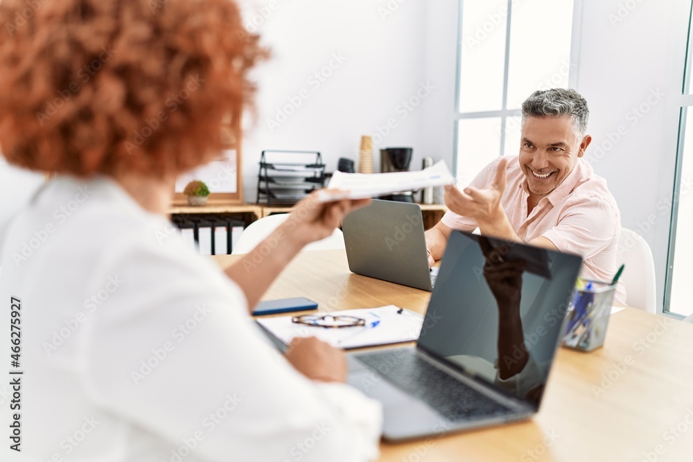 Middle age man and woman business workers using laptop working at office Middle age man and woman business workers using laptop working at office