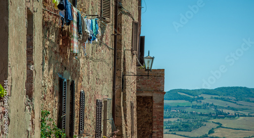 Фотография Clothes hang out on the side of an old rustic medieval house dwelling apartment