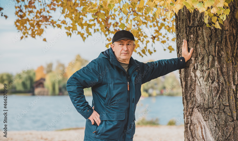 Obraz premium Mature European older man at nature, philosophical portrait, at autumn park