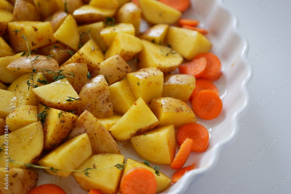 Oven baking vegetables in baking dish, potatoes and carrots with spicy herbs, homemade vegan vegetable dish recipe background Oven baking vegetables in baking dish, potatoes and carrots with spicy herbs, homemade vegan vegetable dish recipe background