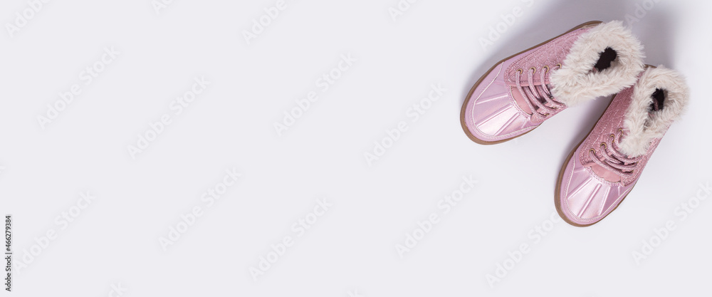 Children's pink shoes on a white background. Top view, flat lay. Banner.