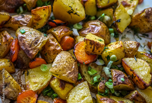 Baked potatoes in the oven with spices and herbs close-up, food background life style, homemade potatoes recipe authentic, vegan cuisine