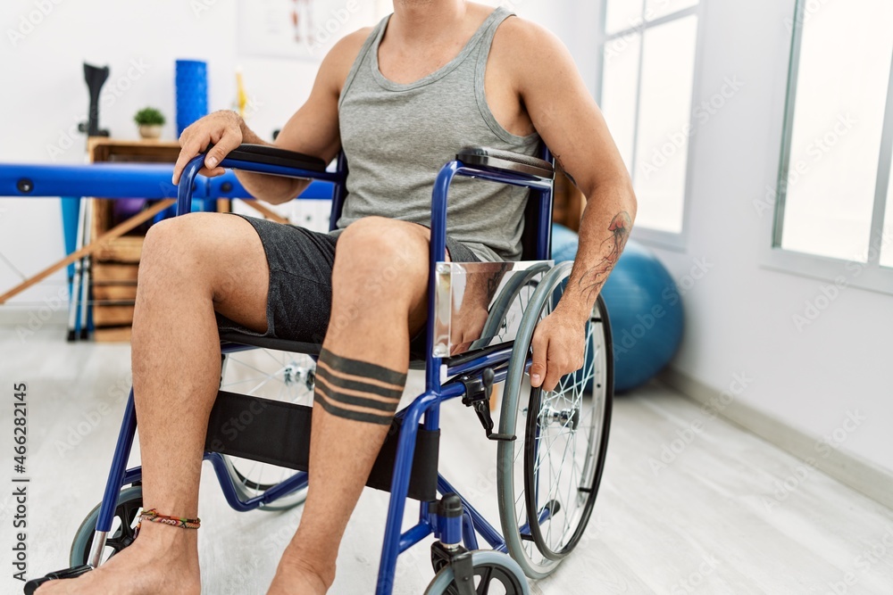 Young hispanic man sitting on wheelchair at clinic Young hispanic man sitting on wheelchair at clinic