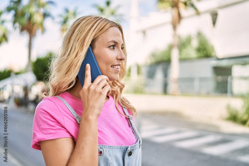 Young blonde woman smiling confident talking on the smartphone at street Young blonde woman smiling confident talking on the smartphone at street