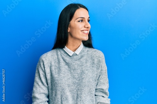 Young hispanic woman wearing casual clothes looking away to side with smile on face, natural expression. laughing confident.