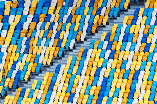 Closeup of yellow and blue seats on stadium photo