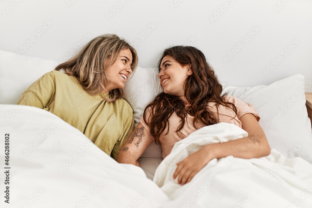 Young beautiful couple smiling happy lying in bed at home. Young beautiful couple smiling happy lying in bed at home.