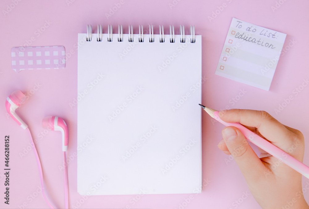 Notepad, headphones and pencil on a pink background. Online education, distance learning.Completing school homework.Flat lay Notepad, headphones and pencil on a pink background. Online education, distance learning.Completing school homework.Flat lay