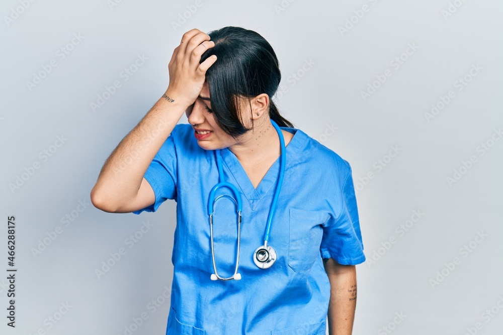 Beautiful hispanic woman wearing doctor uniform and stethoscope surprised with hand on head for mistake, remember error. forgot, bad memory concept. Beautiful hispanic woman wearing doctor uniform and stethoscope surprised with hand on head for mistake, remember error. forgot, bad memory concept.