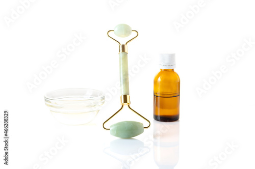 Massage roller and oil bottle. Stone roller for skin and face care. Isolate.