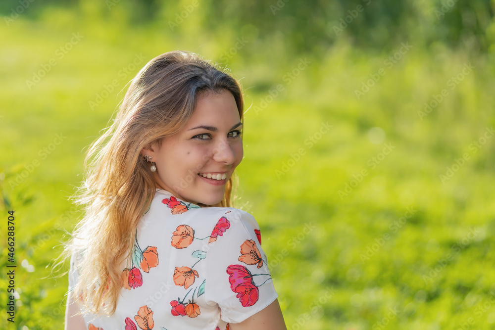 Atractive beautiful young woman is smiling over her shoulder at the camera. Horizontally. Atractive beautiful young woman is smiling over her shoulder at the camera. Horizontally.