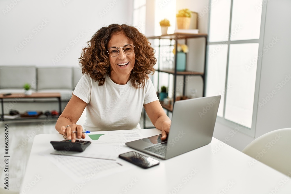 Middle age hispanic woman smiling confident working at home