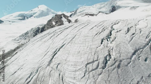 revealing aerial shot of ice mountain glacier in switzerland, massive mountain aerial view of beautiful mountain scenery photo