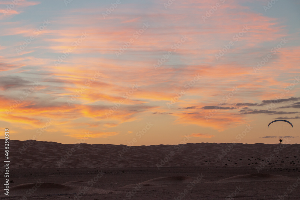 Vol en paramoteur au dessus des dunes dans le désert, coucher de soleil. Tunisie.