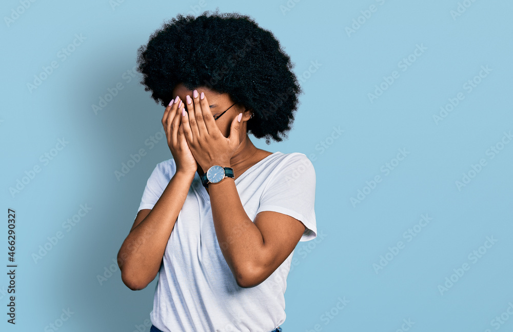 Young african american woman wearing casual white t shirt with sad expression covering face with hands while crying. depression concept. Young african american woman wearing casual white t shirt with sad expression covering face with hands while crying. depression concept.