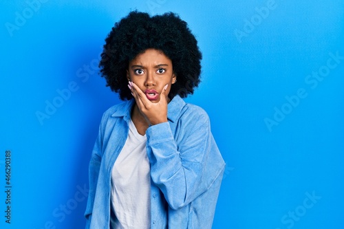 Young african american woman wearing casual clothes looking fascinated with disbelief, surprise and amazed expression with hands on chin