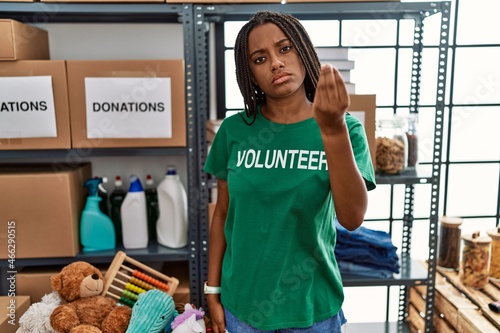 Young african american woman working wearing volunteer t shirt at donations stand doing italian gesture with hand and fingers confident expression