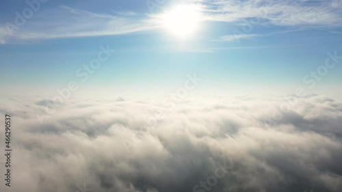 Aerial view up from the clouds to the sky in motion. Aerial view white clouds in blue sky during sunrise or sunset. Aerial cloudscape. Texture of clouds. Panoramic view. Clouds in motion	