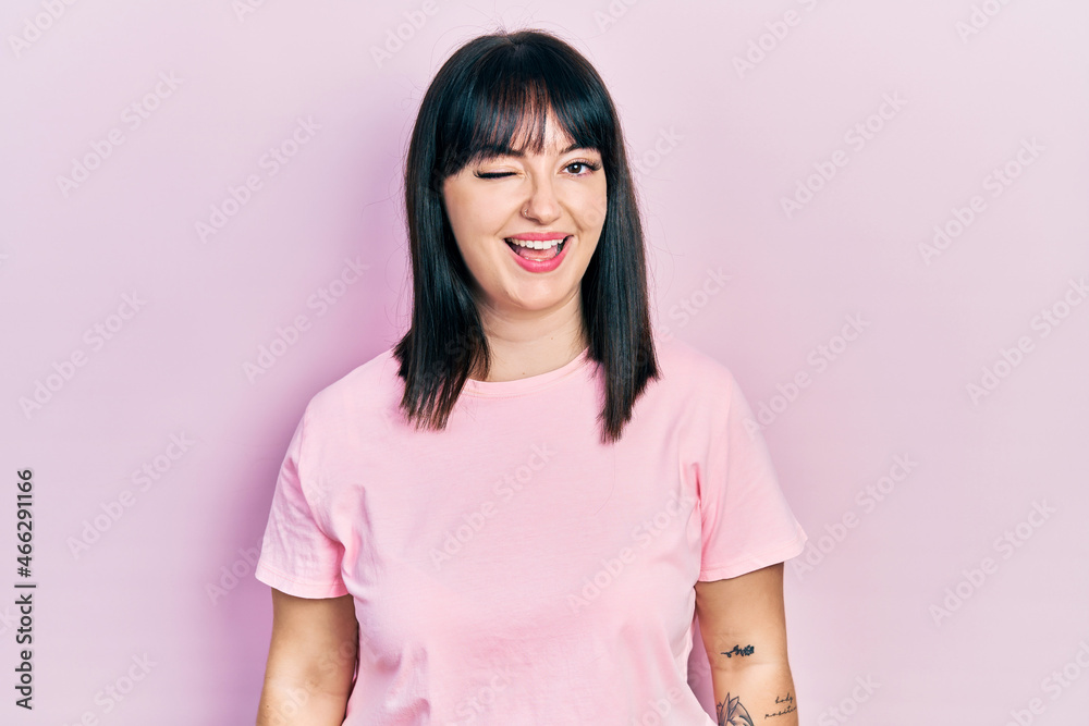 Young hispanic woman wearing casual clothes winking looking at the camera with sexy expression, cheerful and happy face. Young hispanic woman wearing casual clothes winking looking at the camera with sexy expression, cheerful and happy face.