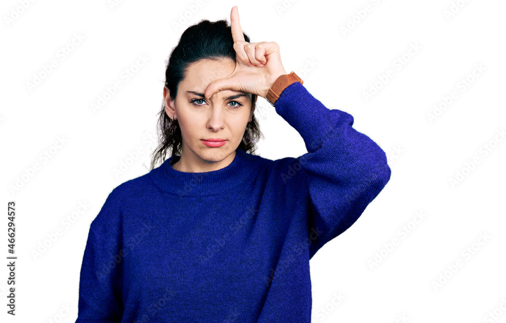 Young hispanic woman wearing casual clothes making fun of people with fingers on forehead doing loser gesture mocking and insulting. Young hispanic woman wearing casual clothes making fun of people with fingers on forehead doing loser gesture mocking and insulting.