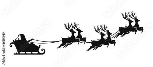 Santa Claus is flying in sleigh with Christmas reindeer. Silhouette of Santa Claus, sleigh with Christmas presents and reindeer
