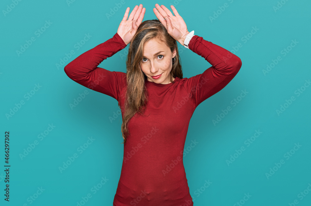Young blonde woman wearing casual clothes doing bunny ears gesture with hands palms looking cynical and skeptical. easter rabbit concept. Young blonde woman wearing casual clothes doing bunny ears gesture with hands palms looking cynical and skeptical. easter rabbit concept.