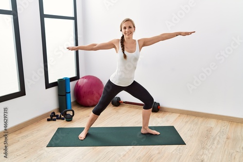 Young caucasian woman smiling confident training yoga at sport center