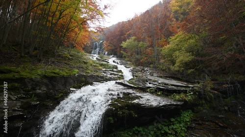 Grande cascata in mezzo a un bosco con colori autunnali photo