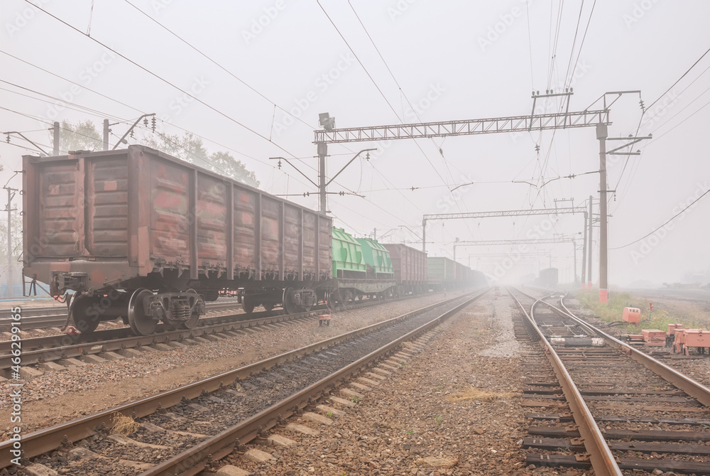 Freight terminal of railway trains. Railway tracks, cars and locomotive in fog. Freight terminal of railway trains. Railway tracks, cars and locomotive in fog.