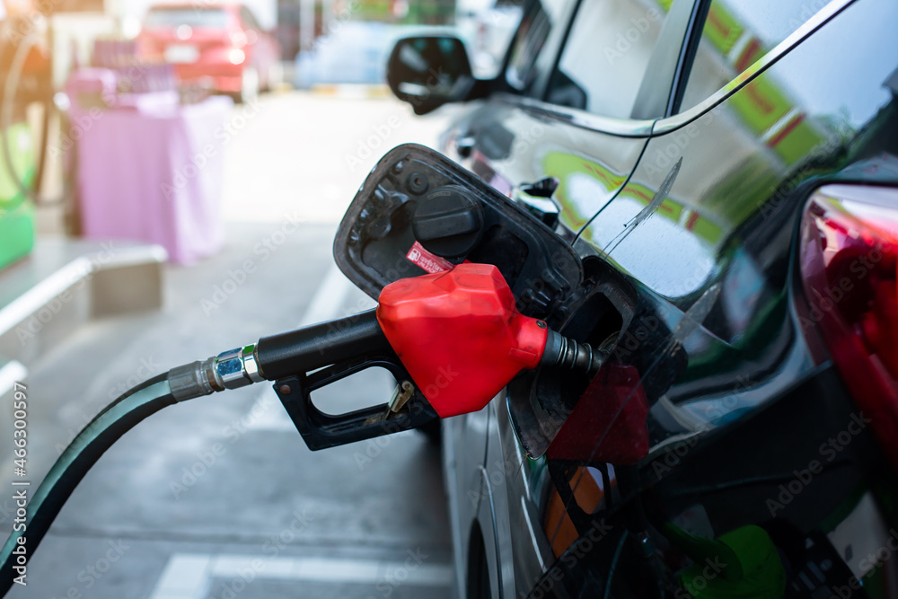 Refilling the car with fuel at the gas station and blurry staff background, refilling the car with fuel at the refuel station, the concept of fuel energy, Blurry image for background. Refilling the car with fuel at the gas station and blurry staff background, refilling the car with fuel at the refuel station, the concept of fuel energy, Blurry image for background.